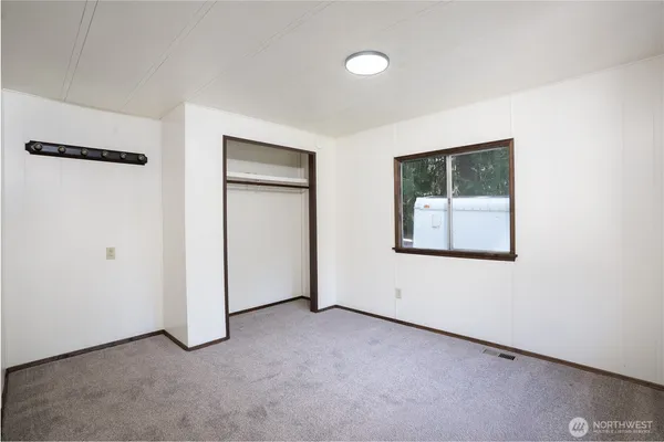 an empty room with windows and closet