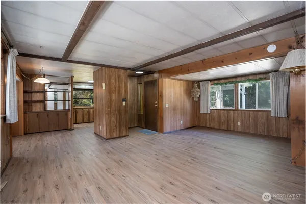 a view of empty room with wooden floor and windows