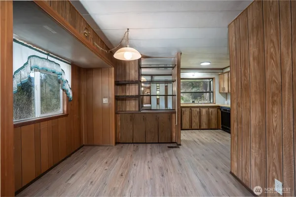 a room with stainless steel appliances wooden floors and large window