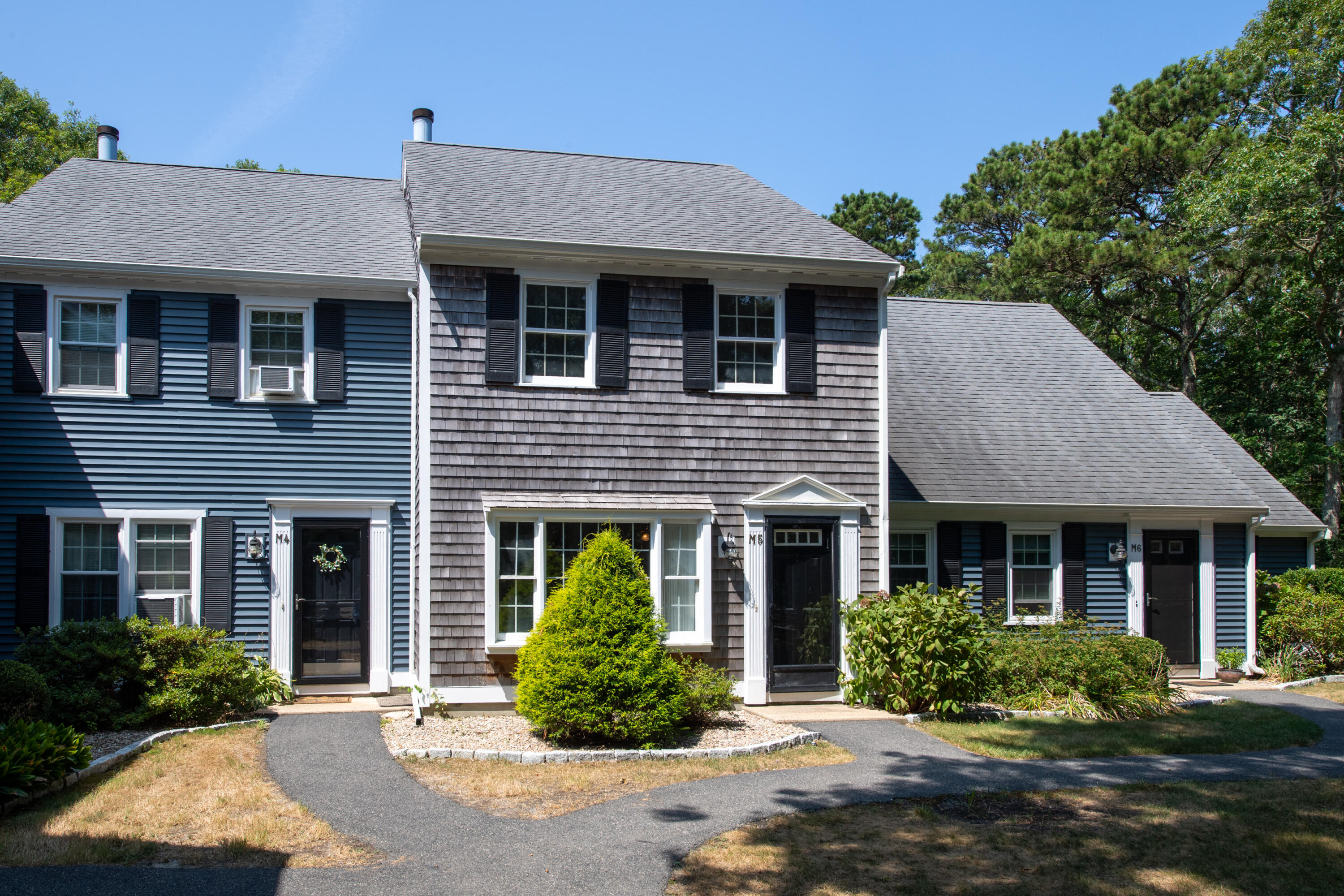 a front view of a house with a yard and potted plants