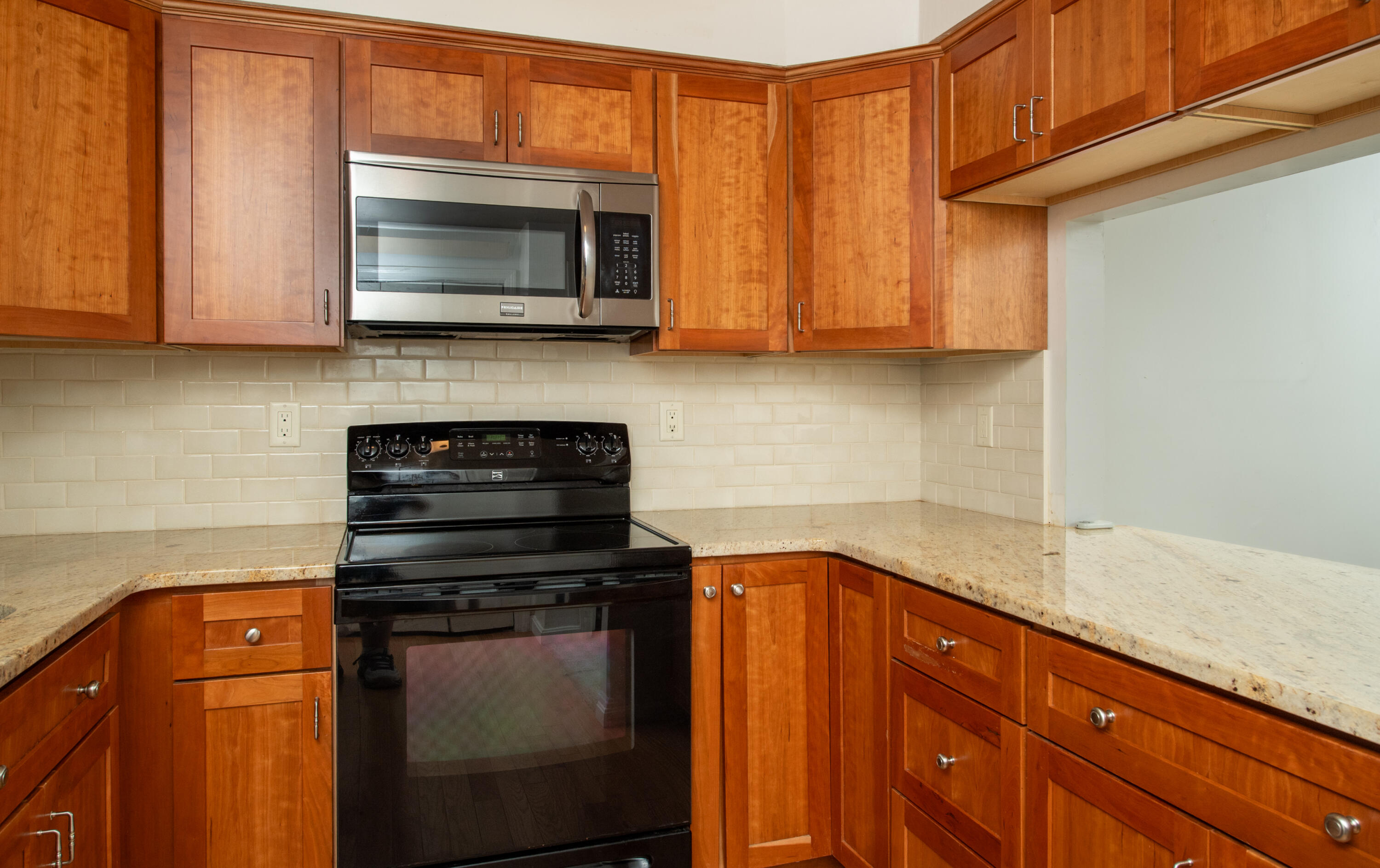 248 Camp Street, Unit M5 West Yarmouth, MA 02673 - Photo 2 of 12 a kitchen with granite countertop wood cabinets and stainless steel appliances