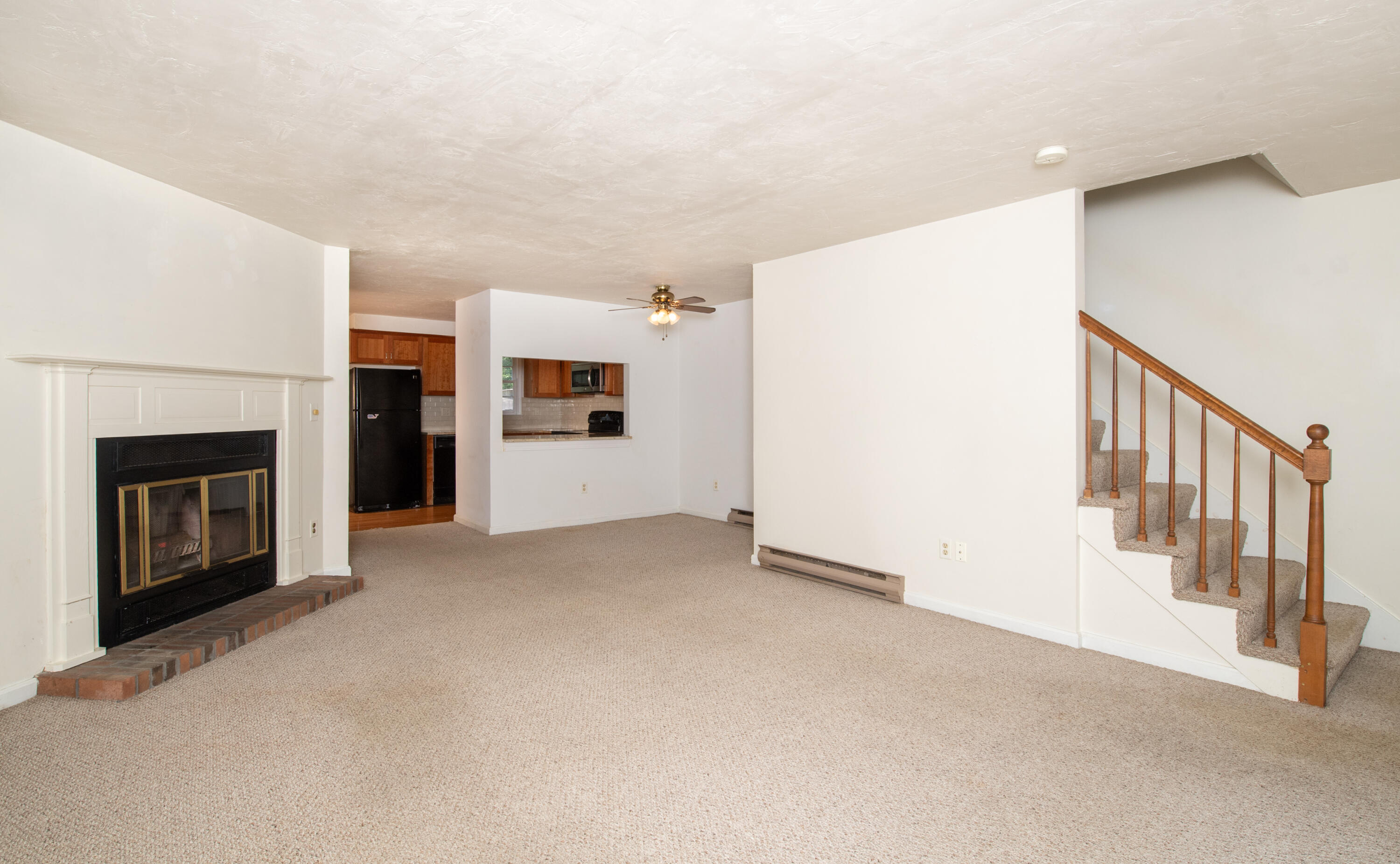 248 Camp Street, Unit M5 West Yarmouth, MA 02673 - Photo 4 of 12 a view of a livingroom with an empty space and a fireplace