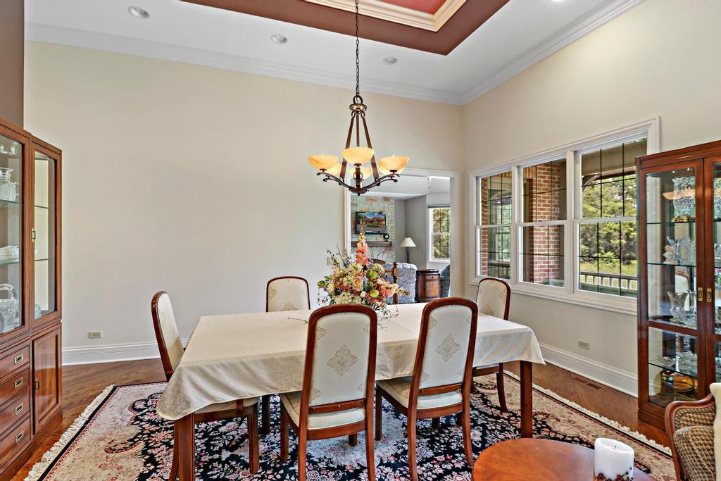 385 Spring Creek Road Barrington Hills, IL 60010 - Photo 13 of 53 a dining room with furniture a chandelier and wooden floor