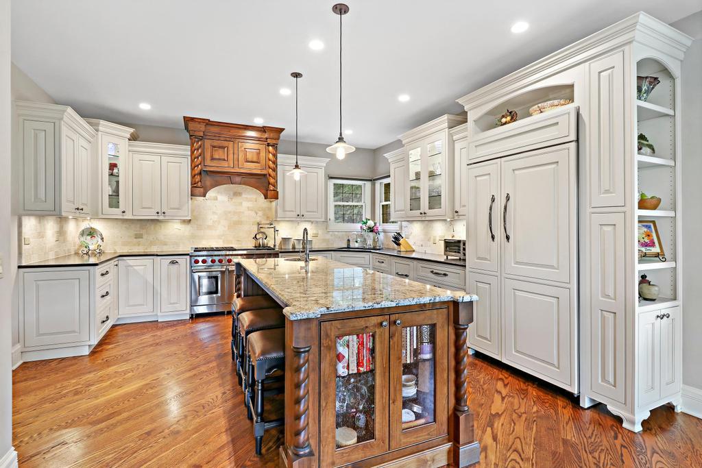 385 Spring Creek Road Barrington Hills, IL 60010 - Photo 18 of 53 a kitchen with stainless steel appliances granite countertop a refrigerator a sink dishwasher a stove and white cabinets with wooden floor