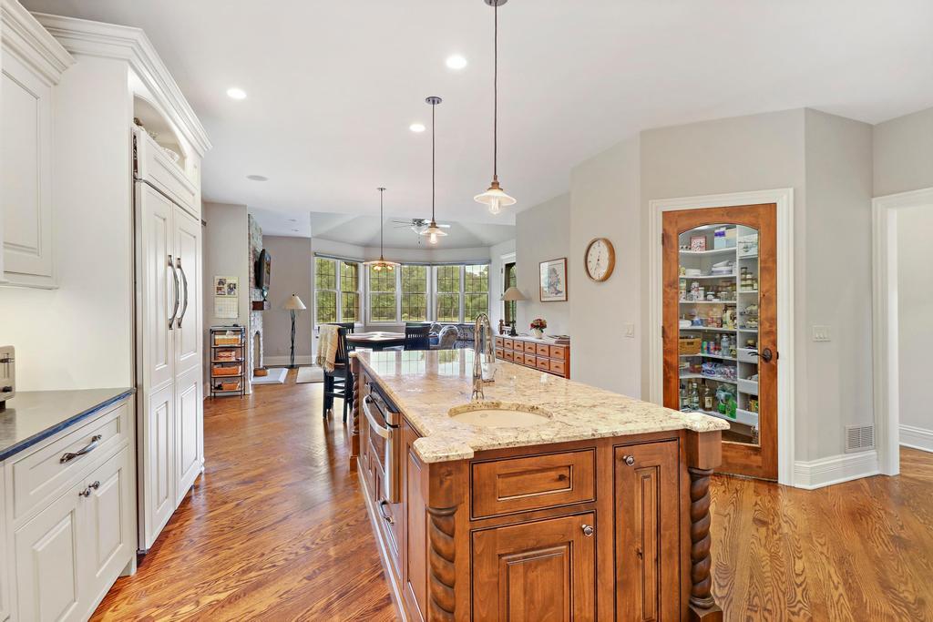 385 Spring Creek Road Barrington Hills, IL 60010 - Photo 19 of 53 a kitchen with stainless steel appliances kitchen island granite countertop a refrigerator a sink dishwasher and a dining table with wooden floor
