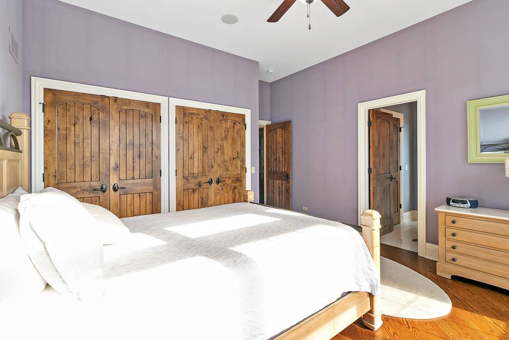 385 Spring Creek Road Barrington Hills, IL 60010 - Photo 31 of 53 a bedroom with a bed and a chandelier