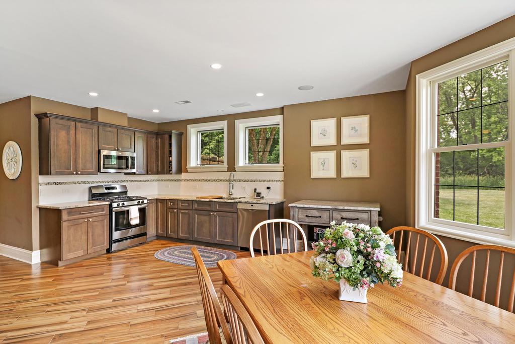 385 Spring Creek Road Barrington Hills, IL 60010 - Photo 36 of 53 a large kitchen with a table chairs wooden cabinets and stainless steel appliances