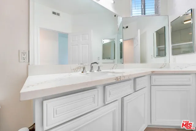 a bathroom with a sink vanity and a mirror