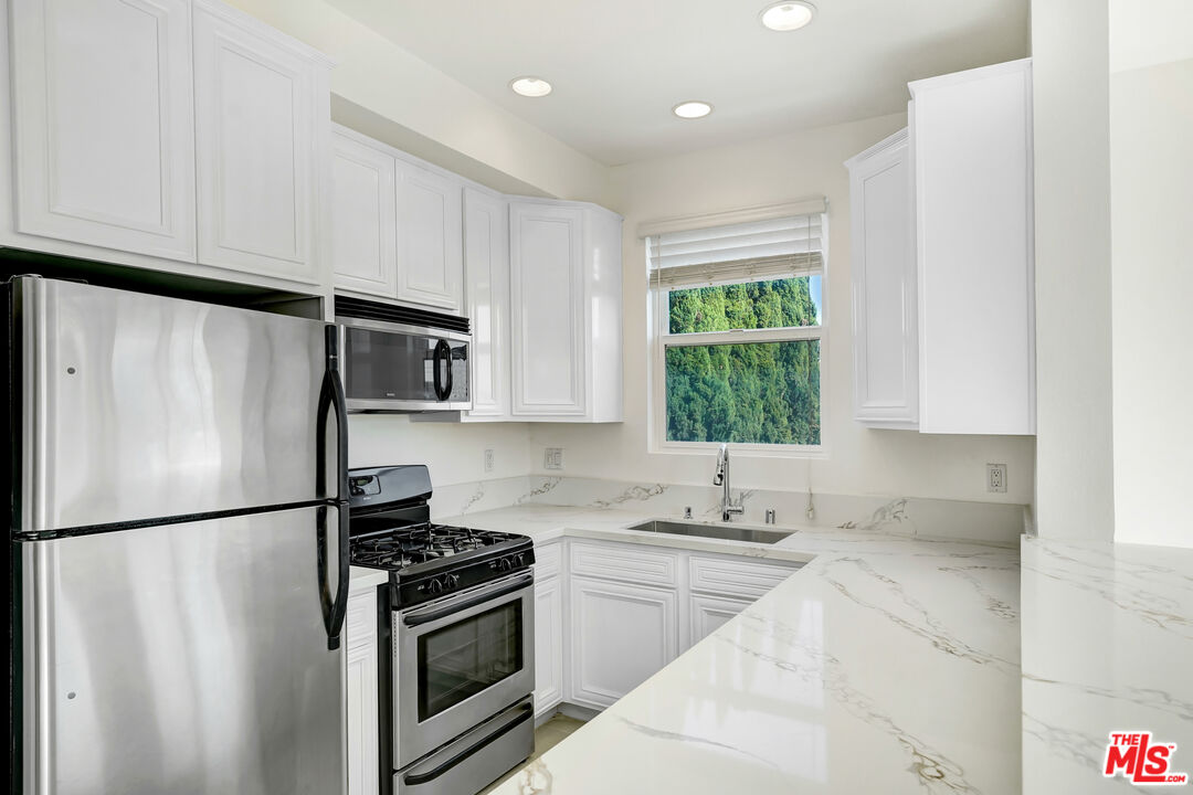 5430 Bellingham Avenue, Unit 306 Valley Village, CA 91607 - Photo 5 of 23 a kitchen with a refrigerator a sink and a stove