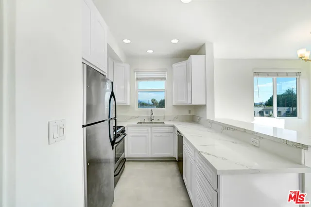 a kitchen with a sink a refrigerator and cabinets
