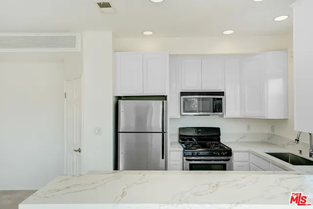 a kitchen with a refrigerator and a stove top oven