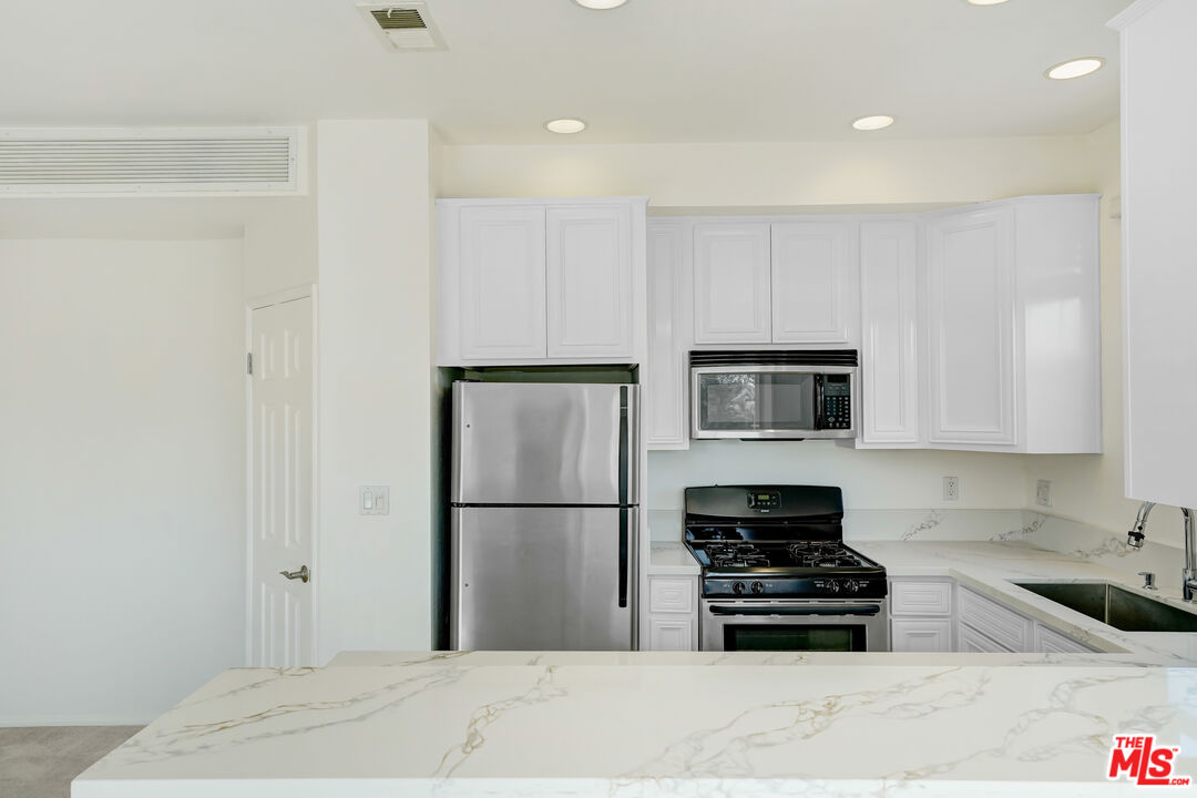 5430 Bellingham Avenue, Unit 306 Valley Village, CA 91607 - Photo 7 of 23 a kitchen with a refrigerator and a stove top oven