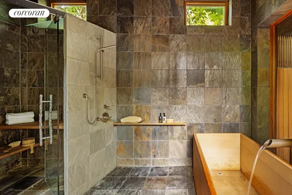 a bathroom with a granite countertop sink a mirror and shower