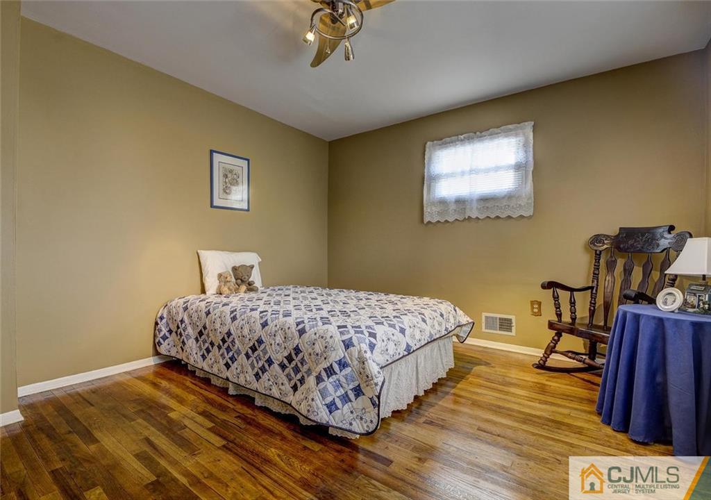 209 North Hill Road Colonia, NJ 07067 - Photo 18 of 18 a bedroom with a bed and wooden floor