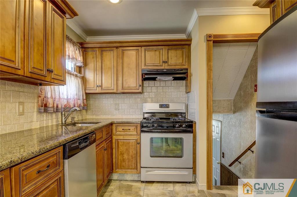 209 North Hill Road Colonia, NJ 07067 - Photo 8 of 18 a kitchen with stainless steel appliances granite countertop a sink a stove and cabinets