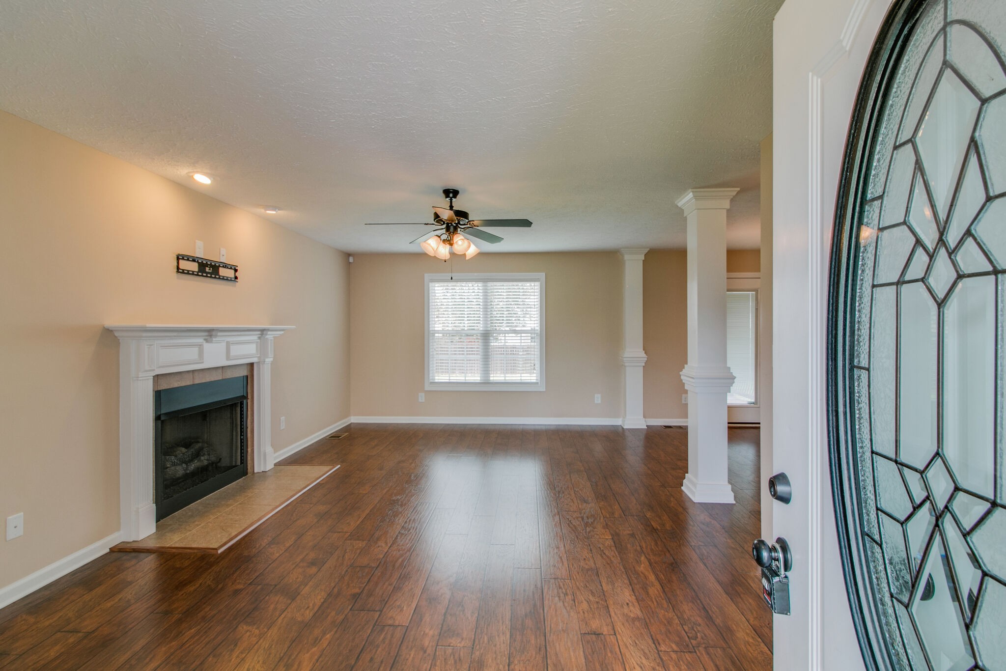 3744 Suiter Road Clarksville, TN 37040 - Photo 5 of 26 an empty room with wooden floor fireplace and windows