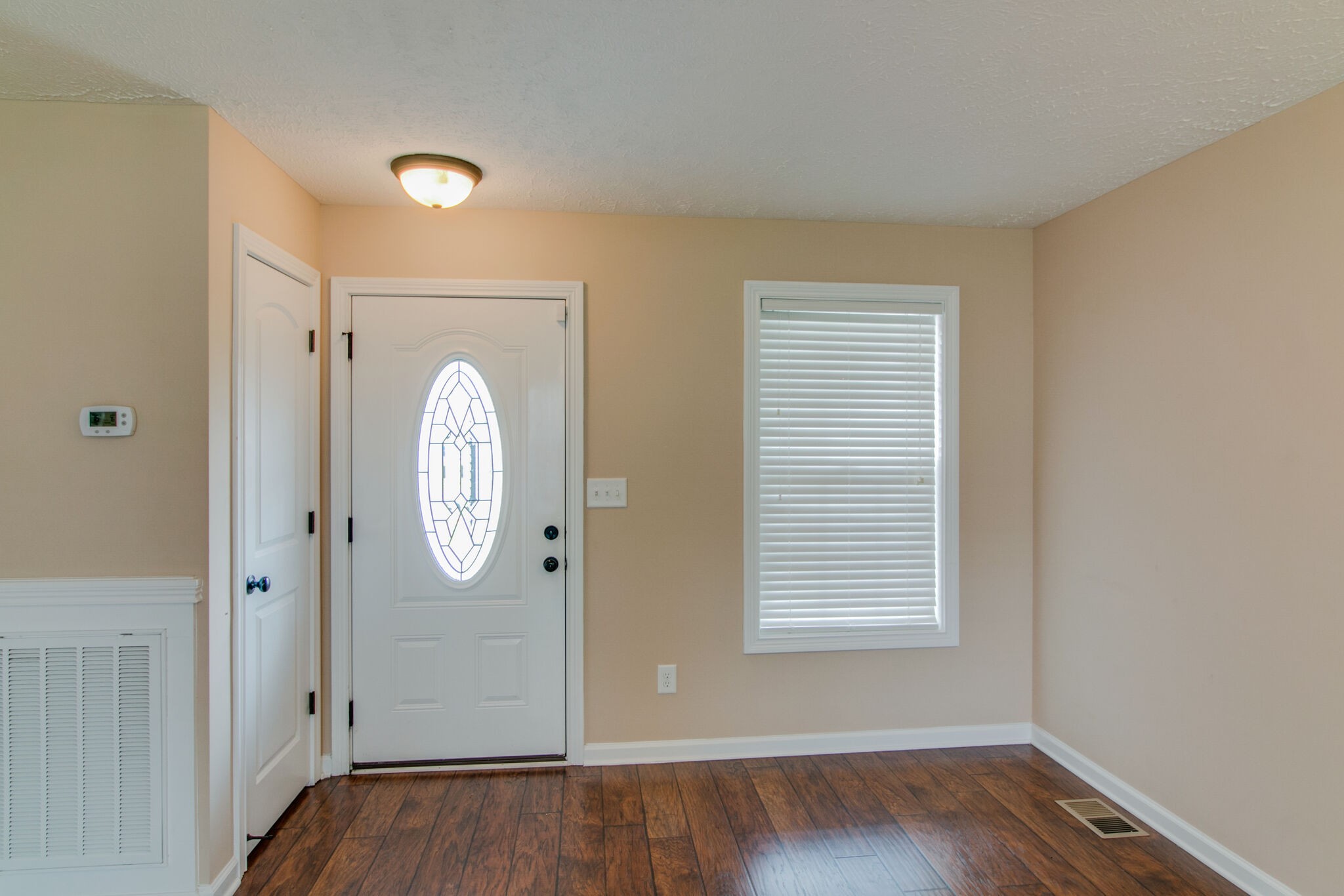 3744 Suiter Road Clarksville, TN 37040 - Photo 6 of 26 an empty room with wooden floor and mirror