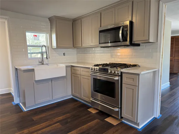 a kitchen with stainless steel appliances a stove a microwave sink and cabinets