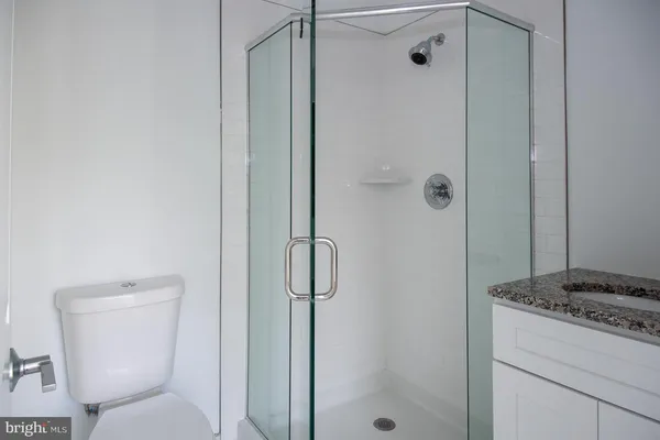 a bathroom with a granite countertop sink toilet and shower