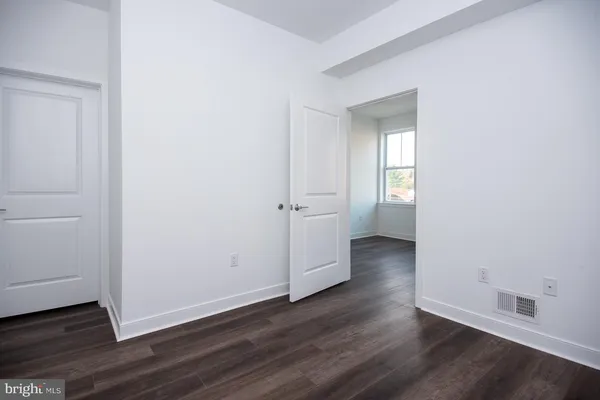 an empty room with wooden floor and closet