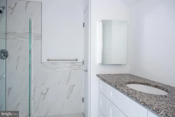 a bathroom with a granite countertop sink and vanity