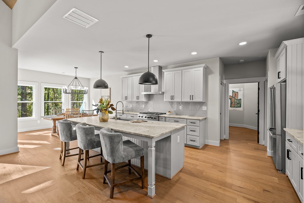 158 Treeline Lane Ellijay, GA 30540 - Photo 61 of 95 a kitchen with stainless steel appliances a dining table chairs stove refrigerator and cabinets