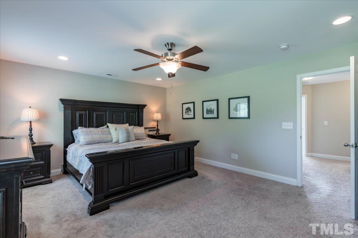 3441 Grosbeak Way Raleigh, NC 27616 - Photo 14 of 25 a spacious bedroom with a bed and a chandelier