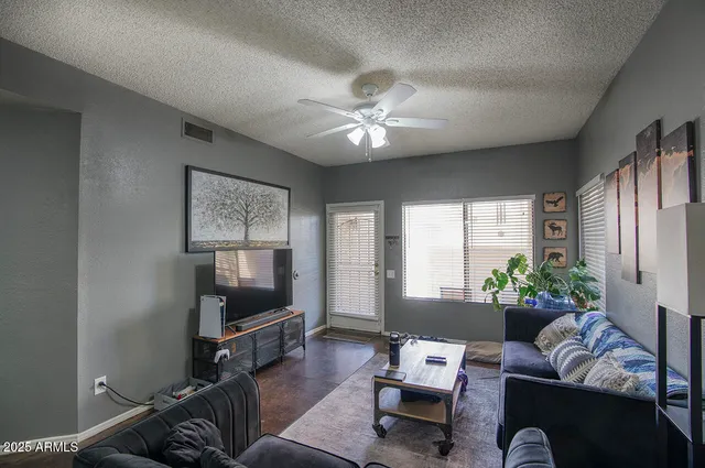 a living room with furniture a flat screen tv and a fireplace