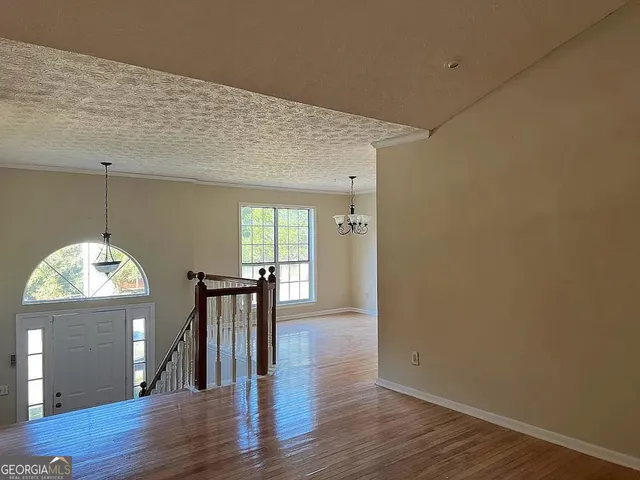 an empty room with wooden floor and mirror