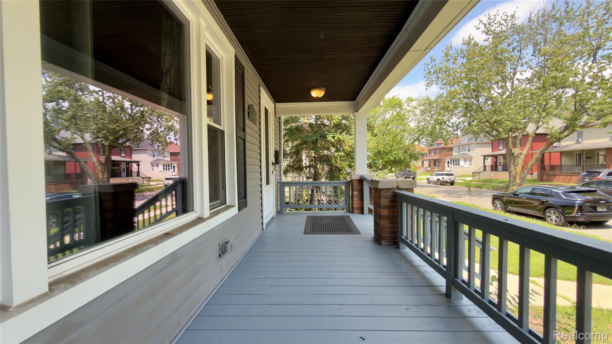 130 Elm Street River Rouge, MI 48218 - Photo 4 of 20 Inviting covered porch with painted decking, brick pillars, and a dark wood-finish ceiling