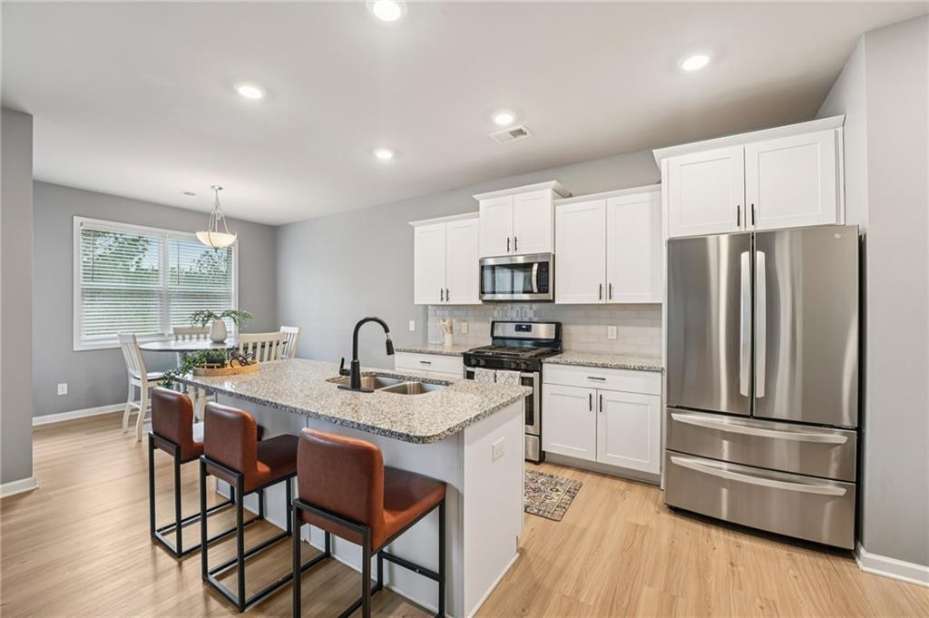95 Denver Avenue Hiram, GA 30141 - Photo 17 of 62 a kitchen with refrigerator cabinets dining table and chairs