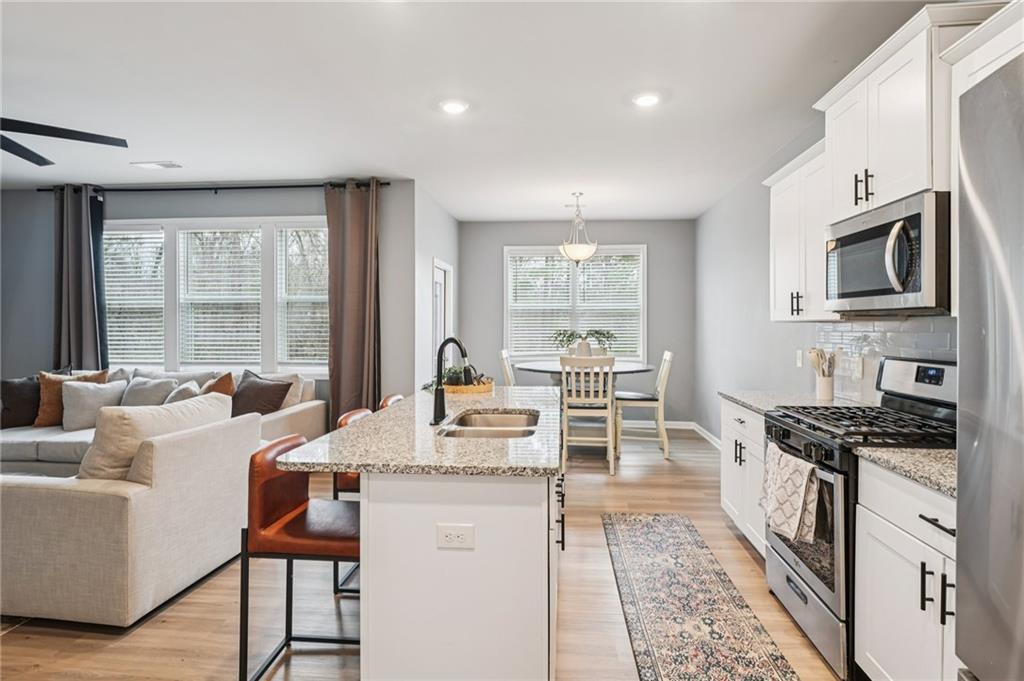 95 Denver Avenue Hiram, GA 30141 - Photo 18 of 62 a open kitchen with granite countertop a sink and a stove top oven