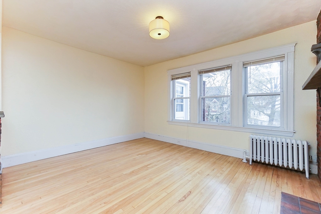 51 Wallingford Road Boston, MA 02135 - Photo 11 of 42 an empty room with wooden floor and windows