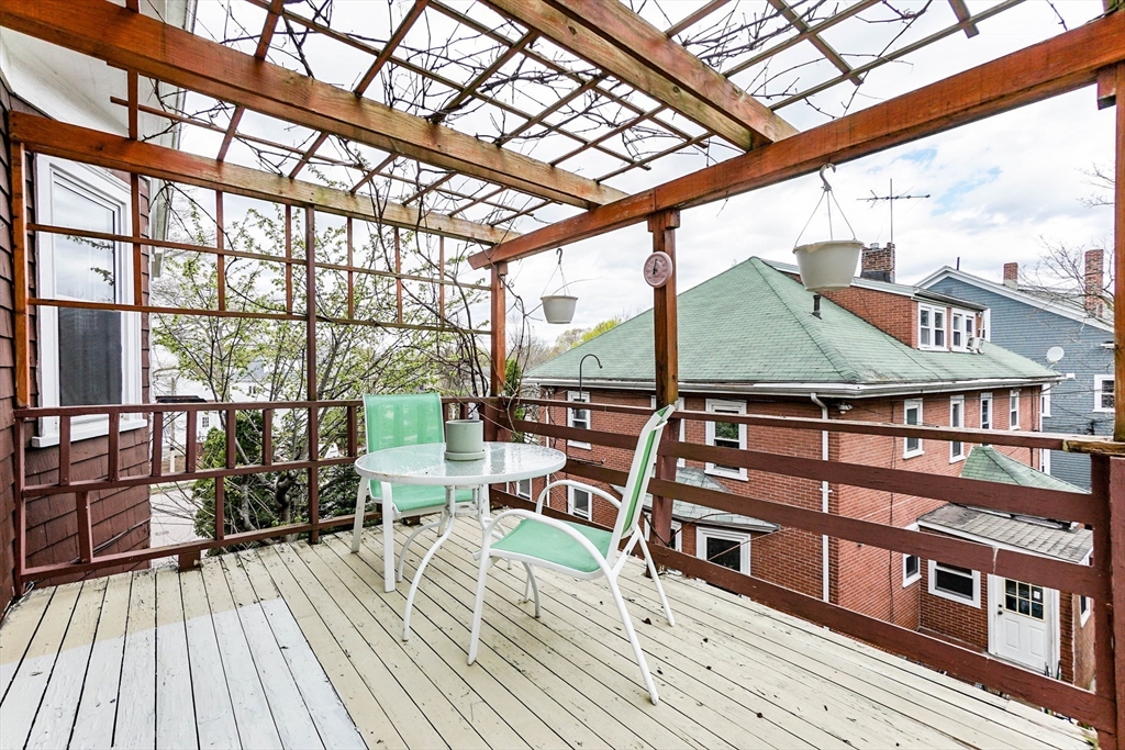 51 Wallingford Road Boston, MA 02135 - Photo 16 of 42 a view of a balcony with chairs and wooden floor