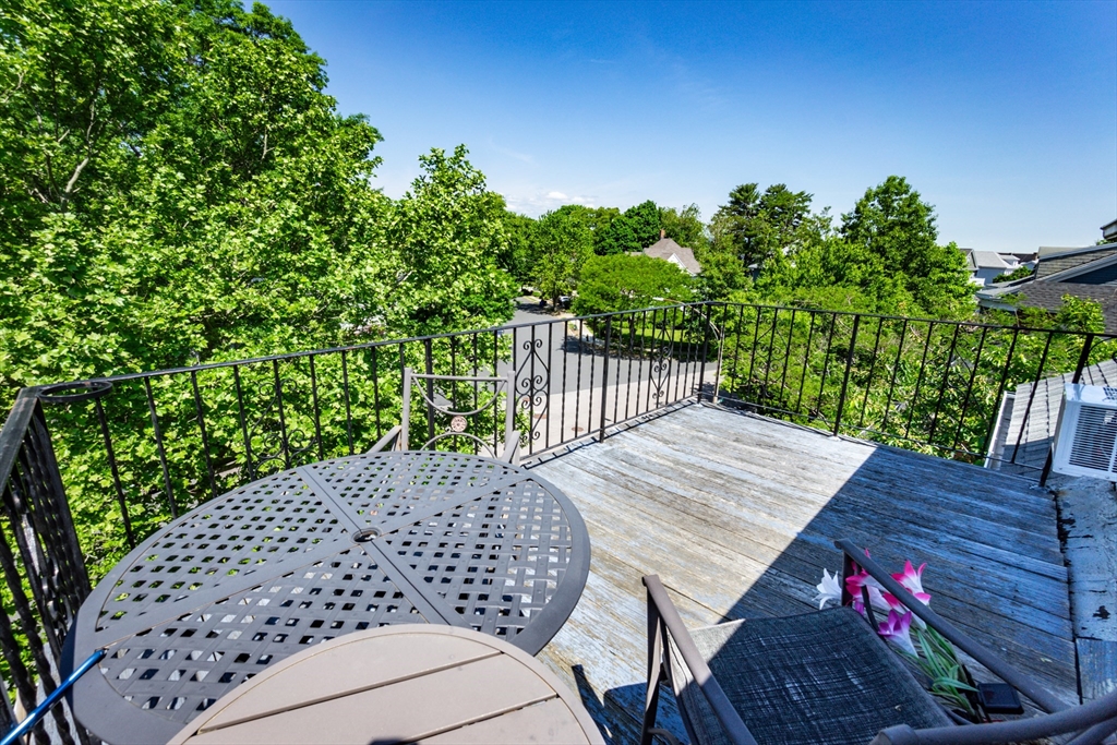 51 Wallingford Road Boston, MA 02135 - Photo 26 of 42 a view of a patio with table and chairs with wooden floor and fence