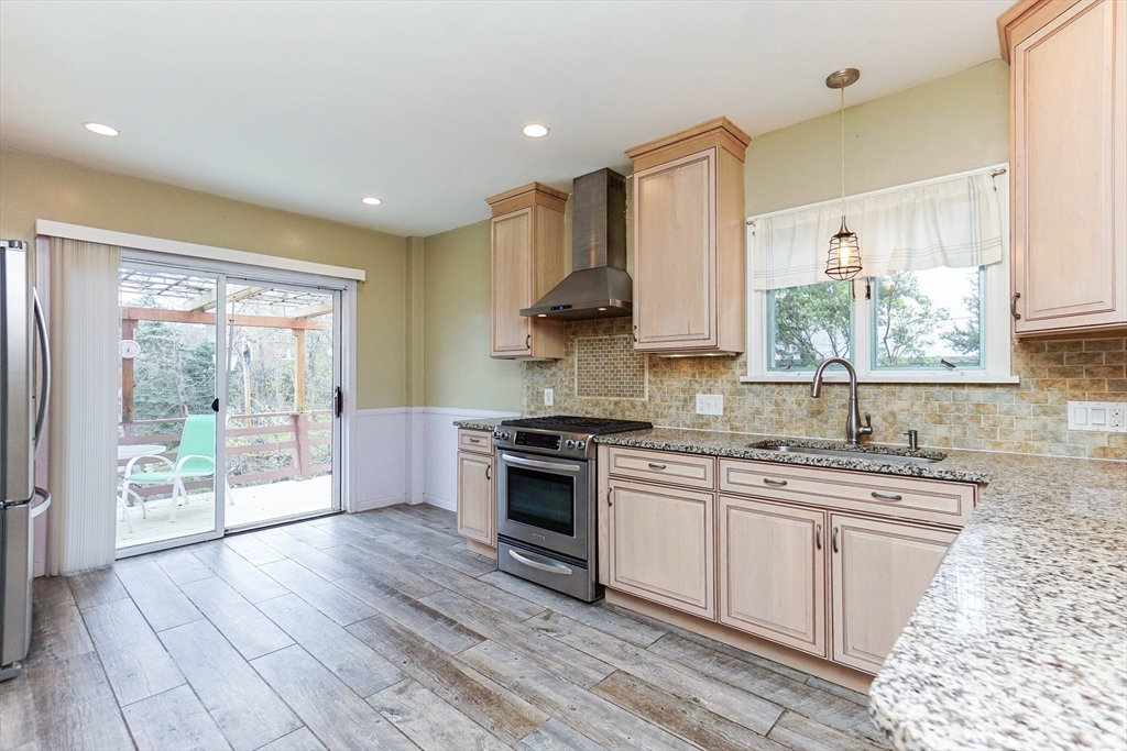51 Wallingford Road Boston, MA 02135 - Photo 3 of 42 a kitchen with stainless steel appliances granite countertop a stove a sink dishwasher and white cabinets with wooden floor
