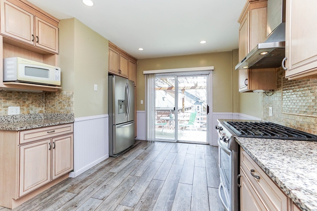 51 Wallingford Road Boston, MA 02135 - Photo 6 of 42 a kitchen with granite countertop wooden floors and stainless steel appliances