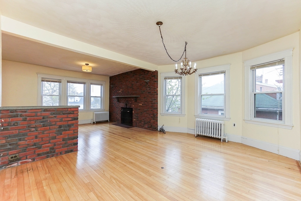 51 Wallingford Road Boston, MA 02135 - Photo 7 of 42 a view of livingroom with hardwood floor and a fireplace