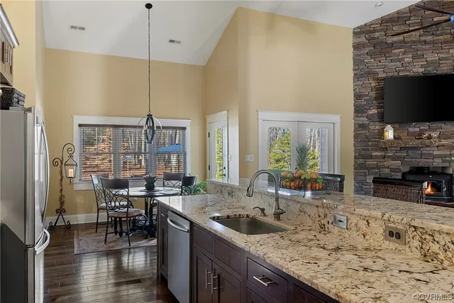 a kitchen with stainless steel appliances granite countertop a stove a sink and a wooden cabinets