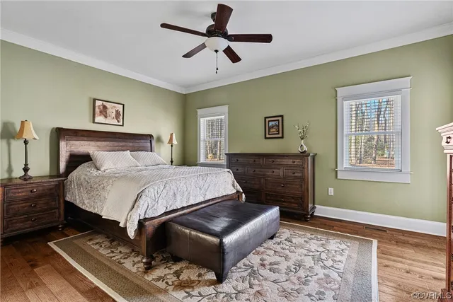 a bedroom with a bed dresser and wooden floor