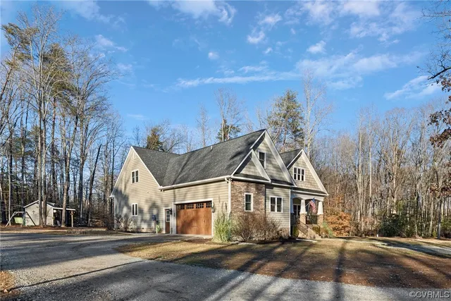 a view of a white house next to a road and yard