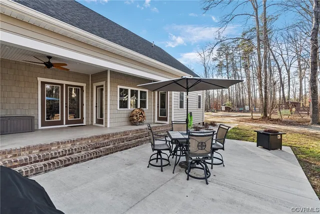 a view of a patio with table and chairs near a barbeque