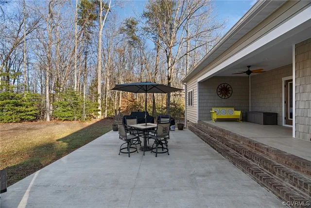 a view of a patio with a table chairs and a backyard