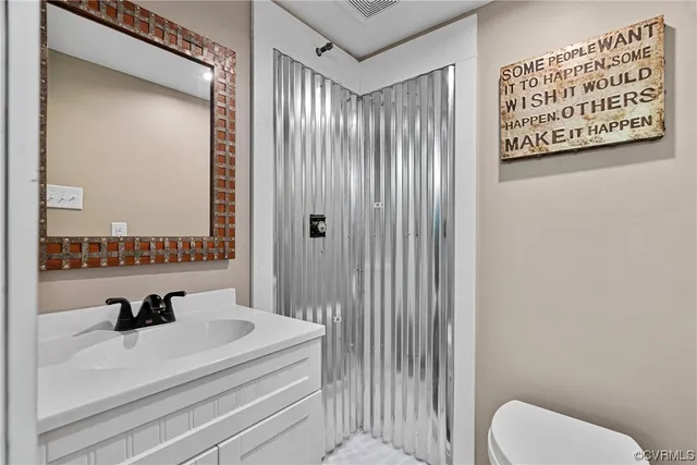 a bathroom with a sink a toilet and a mirror