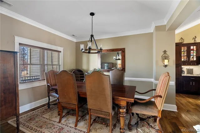 a dining room with furniture a chandelier and wooden floor