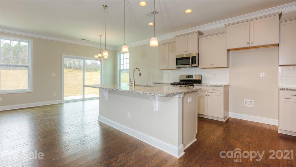 3025 Lydney Circle Waxhaw, NC 28173 - Photo 1 of 1 a kitchen with granite countertop a refrigerator a sink a stove a microwave and wooden floor