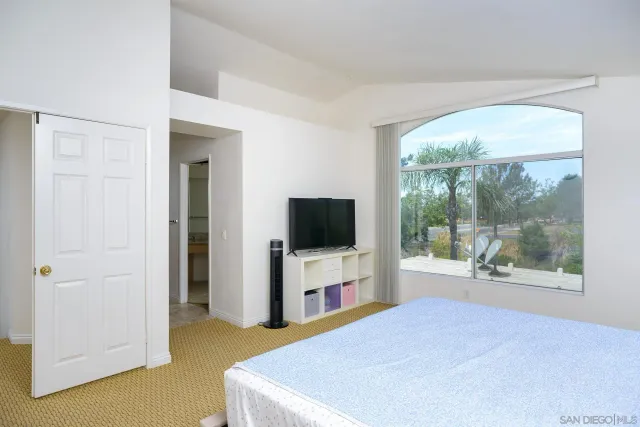 a bedroom with a bed and large flat screen tv