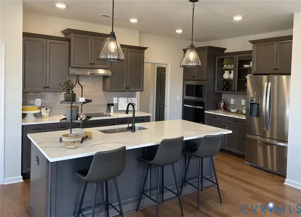 a view of a dining room and livingroom with furniture wooden floor a chandelier