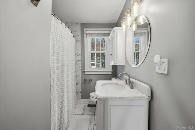 a bathroom with a granite countertop sink a toilet and a mirror