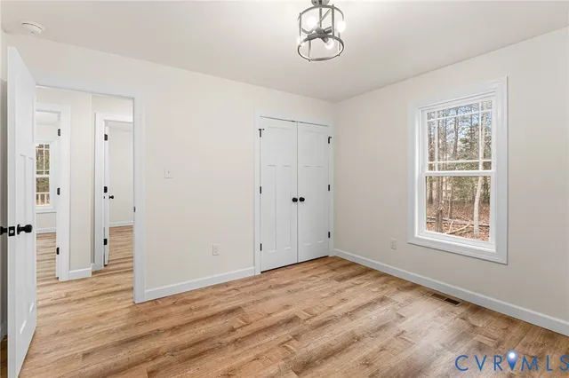 a view of empty room with wooden floor and window